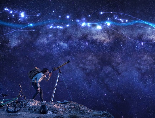 A man with a telescope looking at the milky way.  | The White Leaf 
