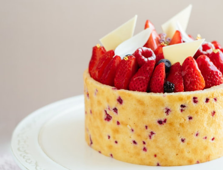 A cake topped with berries and white chocolate. | The White Leaf 