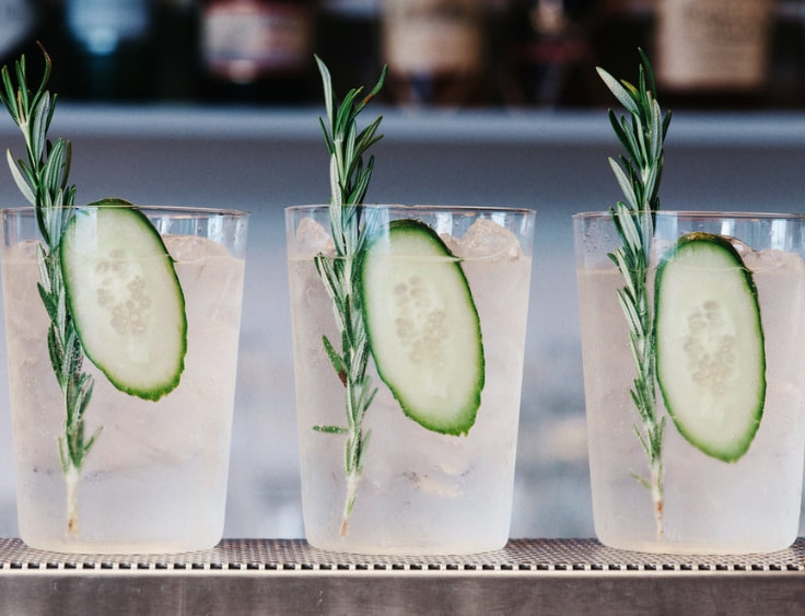 Three glasses of gin with cucumber and sprigs of rosemary. | The White Leaf 