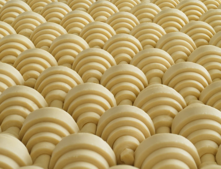A close up of a bunch of yellow shaped doughnuts. 