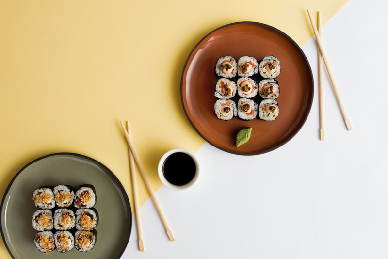 plates with sushi, soy sauce and chop sticks