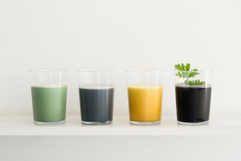 4 glasses of liquid with many colours and vegtables