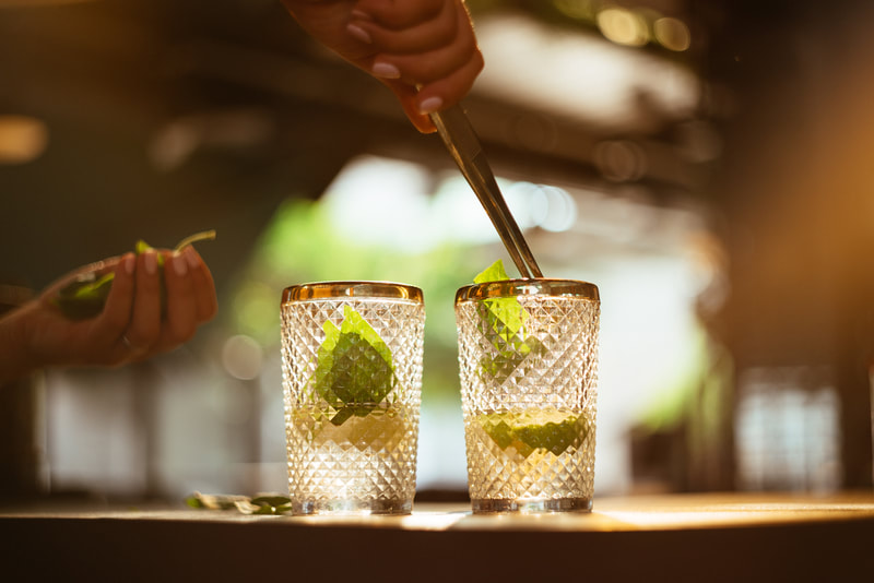 bartender adding leaves to a cocktail